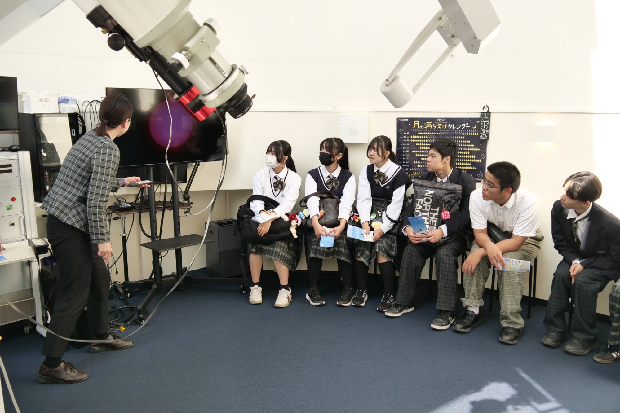海星館の天文ドームで説明を聞く生徒たち