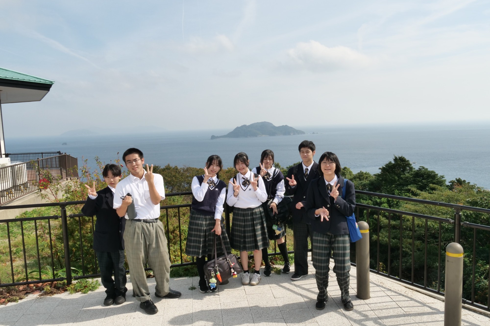 豊予海峡を挟み、佐田岬方面を望む展望台の生徒たち